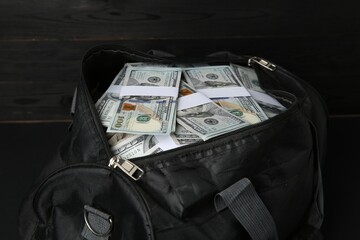 Dollar banknotes in bag on black table, closeup