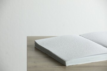 Book with Braille text on wooden table. Education and leisure for blind people