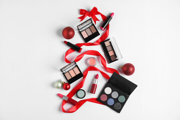 Christmas tree shape made with makeup products and decor on white background