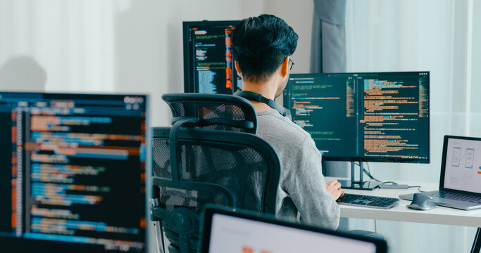 Young adult Asia male freelance eyeglasses typing write prompt AI bot IT app smart program nomad, video game, terminal with coding, user interface, designer, big data center on desktop computer.