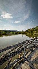 Scenic part of the educational trail Ol&scaron;ina in the &Scaron;umava region, with a wooden path winding through wetlands, meadows and trees. 
