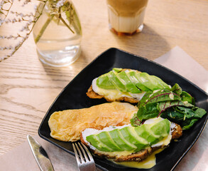 Blogger enjoying healthy breakfast with avocado toast and latte
