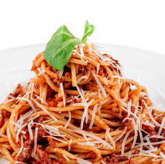 Delicious spaghetti bolognese with basil leaf topping being served on white plate