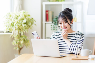 リビングでテレワークをする若い女性。