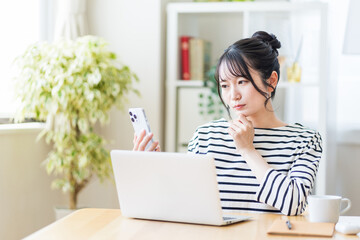 リビングでテレワークをする若い女性。