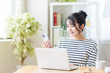 リビングでテレワークをする若い女性。