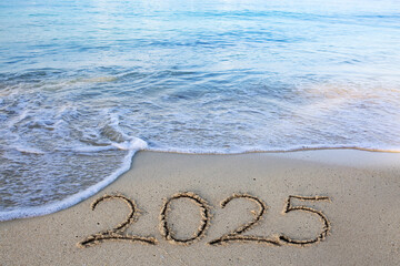 2025 hand written in sand on a beautiful beach