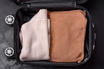 An open suitcase with wheels with clothes inside. Preparing for your trip