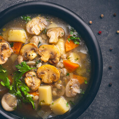 Mushrooms transparent healthy soup with champignon, vegetables and pearl barley. Simple, full of vegan protein cuisine for the cold season. Forest food, vegan proteins. Baltic , Scandinavian cuisine