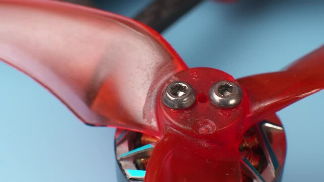 Close-up macro of unscrewing screws securing propellers to brushless motor of self-assembled drone