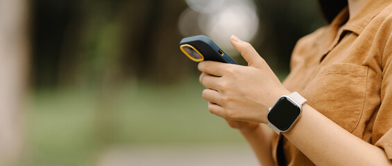 Smartwatch and Smartphone Connection:  Close-up of a woman's hands, showcasing a sleek smartwatch and a smartphone, symbolizing the seamless integration of technology in modern life. 