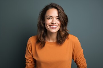 Obraz premium Portrait of a smiling woman in her 30s sporting a long-sleeved thermal undershirt isolated on solid color backdrop