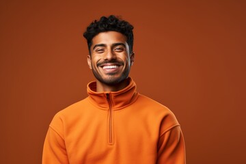 Obraz premium Portrait of a glad indian man in his 20s wearing a thermal fleece pullover isolated in solid color backdrop