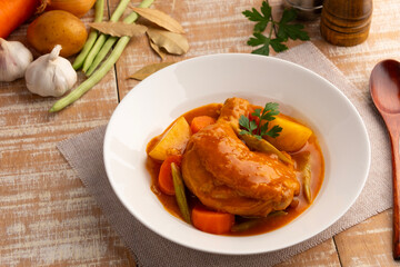 Asian style chicken stew in white plate.Slow cooked chicken,a rich and hearty mix of tender chicken and crispy skin smothered in gravy-like sauce.