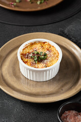 Elegant Julienne with Mushrooms and Cheese in Rustic Ramekin on Dark Background