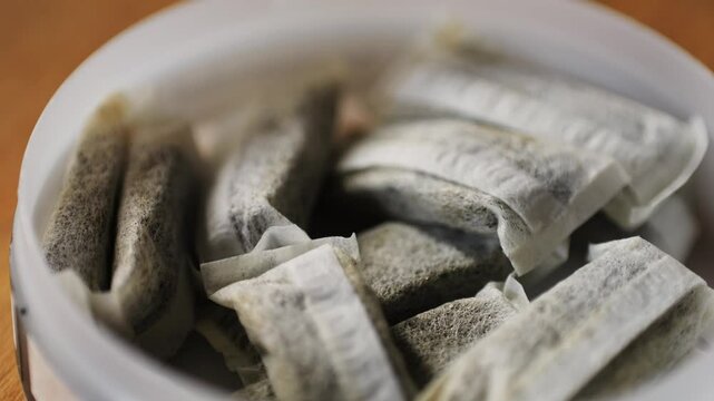 Snus nicotine tobacco close up, pack of tobacco for gum. unhealthy addiction.