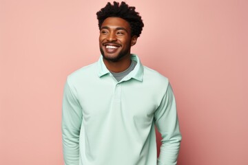 Obraz premium Portrait of a cheerful afro-american man in his 20s wearing a breathable golf polo over solid pastel color wall
