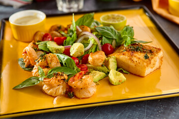 Fresh Seafood Assortment with Shrimp, Scallops, Fish, Avocado, and Cherry Tomatoes on a Yellow Plate