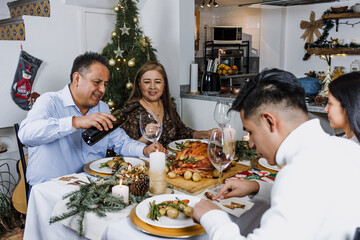 Mexican family having Christmas dinner and making wine toast at home in Mexico Latin America, hispanic teenagers daughter, son, mother and father