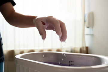 Parafinbad. Hand in Behandlung, Ergotherapie, Physiotherapie. Behandlung mit Paraffin.