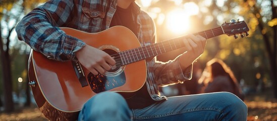 Obraz premium Man playing acoustic guitar in the park