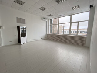 Empty modern loft room with large windows and structural beams, highlighting a spacious and bright interior. Room minimalist design for various uses and creativity.