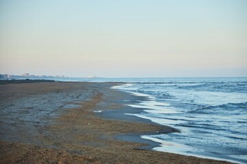 The Caspian Sea is calm and the sky is blue. The water is choppy and the waves are small