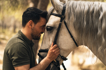 Horse and man affectionately putting their heads together. Connection between man and nature. Love for animals