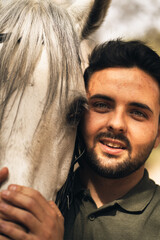 Portrait of a man and his horse facing the camera. Close-up of the two. Concept of love for animals.