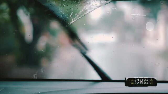 Raindrops on a windshield and cleaned by car wipers with bokeh background