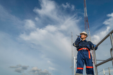 Engineer in Full Safety Gear Climbing a Ladder to Inspect Communication Signals and Industrial Machinery at a High-Risk Transportation Facility