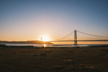 Obraz premium [HYOGO]Sunset view of Akashi Kaikyo Bridge, known as one of the world's largest suspension bridges, The orange sunset sky is beautiful, Azur Maiko, Japan