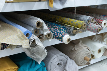 Shelving with rolls of fabric in a clothing store