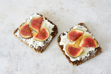 a slice of bread with sliced fig, ricotta and honey on top