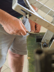 Mechanic cleaning a tiny part with a wire brush in a workshop