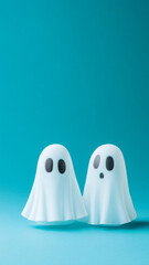 Cute white ghosts on minimalist color background with copy space