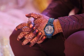 A beautiful bridal hand featuring intricate henna designs. The rich, dark henna contrasts elegantly...