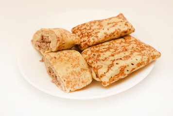 Pancakes with meat on a white plate. Pancakes with filling.