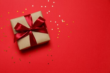 Obraz premium Beautiful gift box with confetti on a colored background
