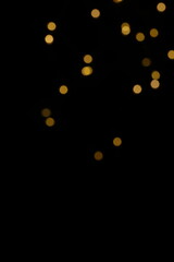 Golden blurred bokeh lights on black background. Glitter sparkle stars for celebrate. Overlay for...