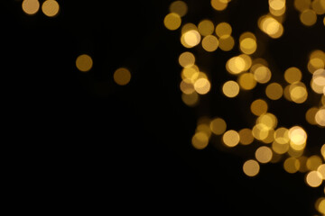 Golden blurred bokeh lights on black background. Glitter sparkle stars for celebrate. Overlay for your design
