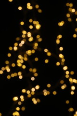 Golden blurred bokeh lights on black background. Glitter sparkle stars for celebrate. Overlay for your design