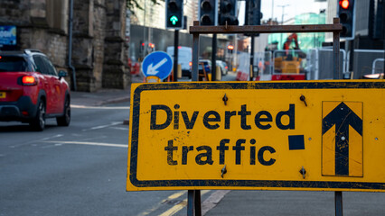 Obraz premium Yellow Diverted Traffic Sign on a City Street