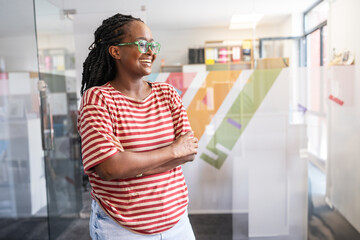 In her student support office, a determined black female student stands confidently.	