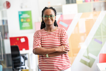In her student support office, a determined black female student stands confidently.	