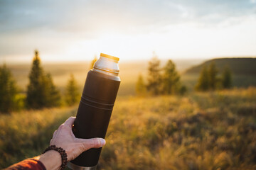 Adventure Awaits Grasping a Water Bottle While Reveling in a Beautiful Sunrise Landscape That...
