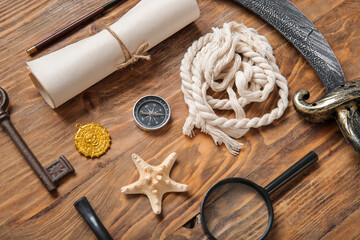 Different pirate equipment on brown wooden background
