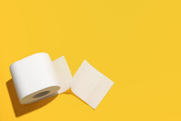 Roll of toilet paper on yellow background
