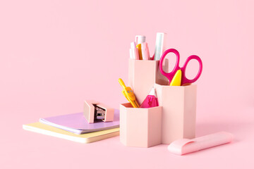 Holder with different stationery on pink background
