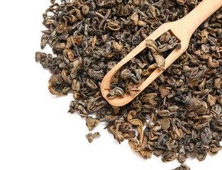 Wooden scoop with dry green tea leaves on white background